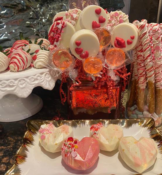 Love the sweet Valentine’s Day packages and baskets, which included heart shaped cocoa bombs, chocolate covered strawberries, chocolate covered pretzel rods, chocolate covered Oreo pops and home made strawberry flavored and gold leaf lollipops. All decorated in white, red and pink chocolate with edible glitter! 