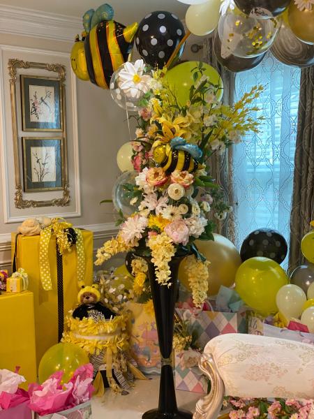 Over sized floral arrangement in our 4 feet black glass vase using a variety of fresh flowers in yellow, white and pink for the Mommy to bee baby shower.