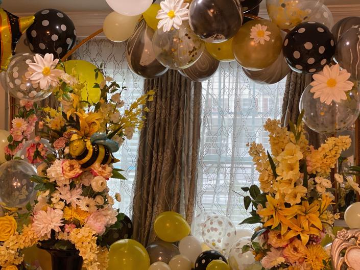 Black and yellow balloons with different size bee mylar balloons for our Bee inspired balloon arch. We also had large floral centerpieces