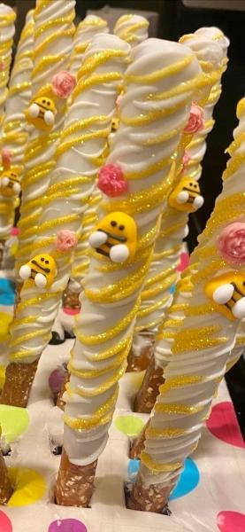 White and yellow baby bee chocolate covered pretzel rods for the Sweet as can Bee dessert table at the Mommy to Bee baby shower