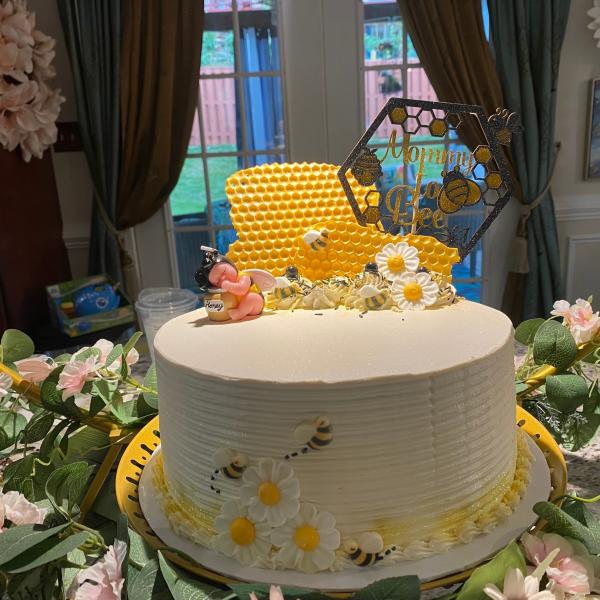 Baby shower cake decorated with edible daisy's, bumble bees and chocolate honey combs for the Sweet as can Bee dessert table 
