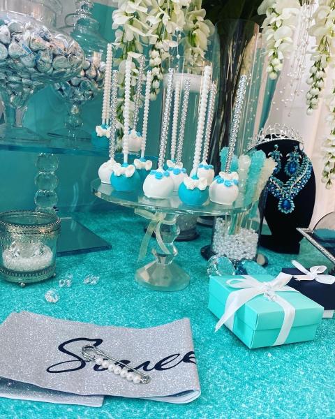 Cake pops, cupcakes, macarons, chocolate kisses, chocolate covered pretzels and the Tiffany Box cake adorned the dessert table at the Tiffany birthday party