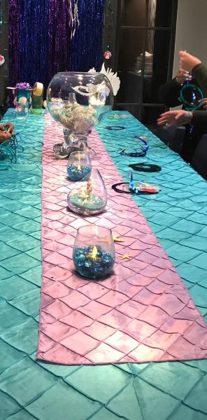 Ode to the little mermaid, under the sea baby shower guest table decorated in purple and teal Pintuck linen, tea lights and mermaid fish bowl